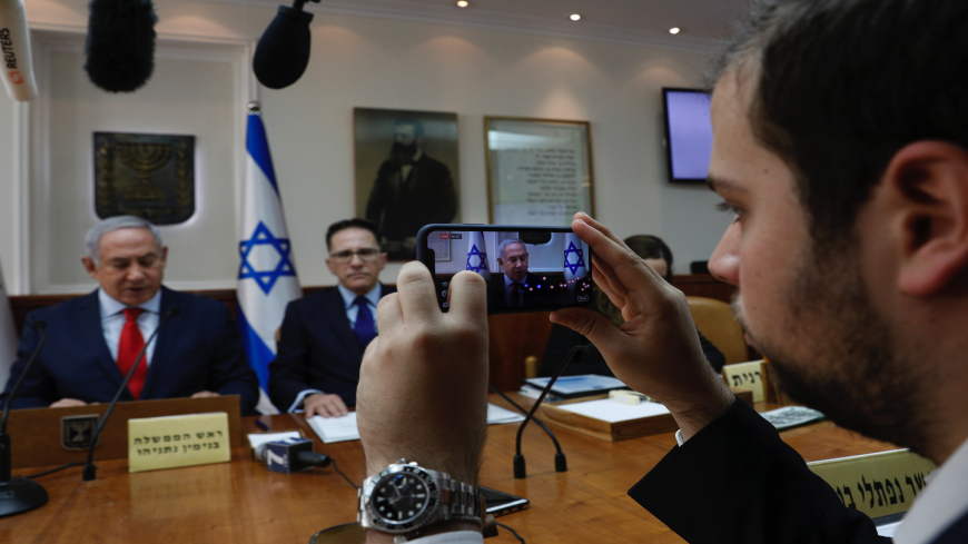 A media adviser of Israeli Prime Minister Benjamin Netanyahu makes a Facebook live broadcast as he opens the weekly Cabinet meeting at his Jerusalem office on Jan. 21, 2018.